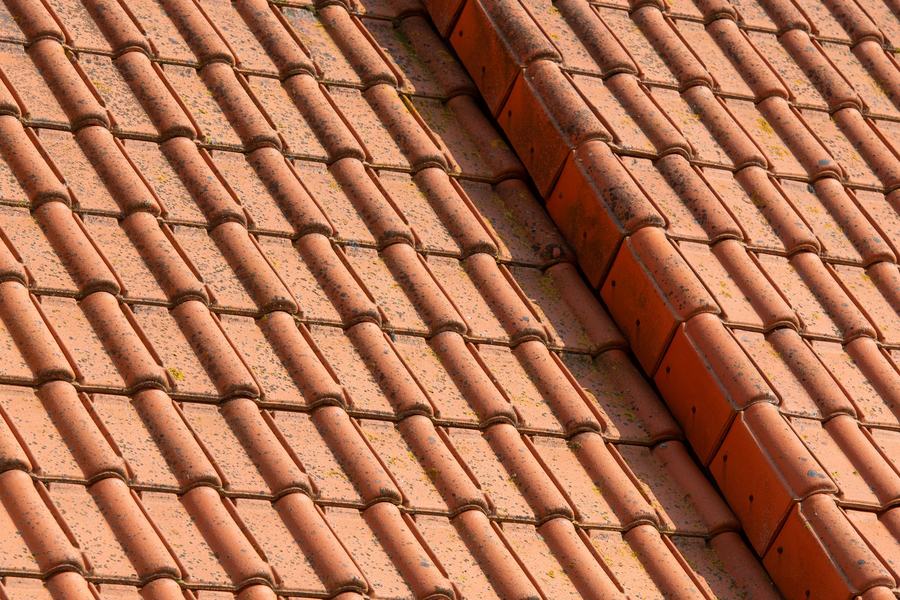 Pente de toit en tuiles canal terracotta avec sa tuile faîtière